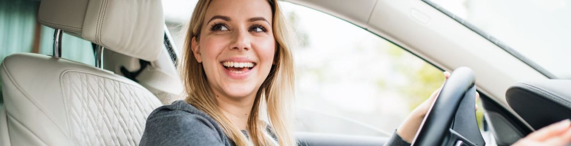 rapariga a conduzir carro a sorrir