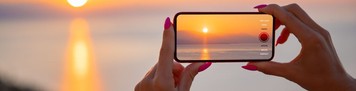 Woman taking sunset photo 