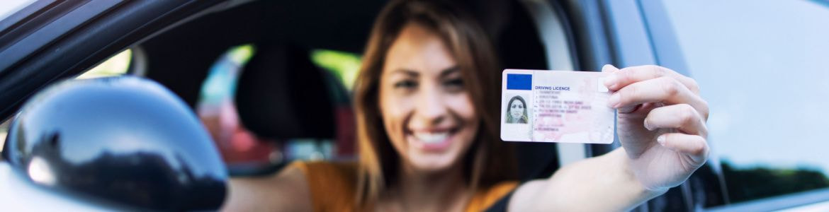 Woman in car showing driver's license
